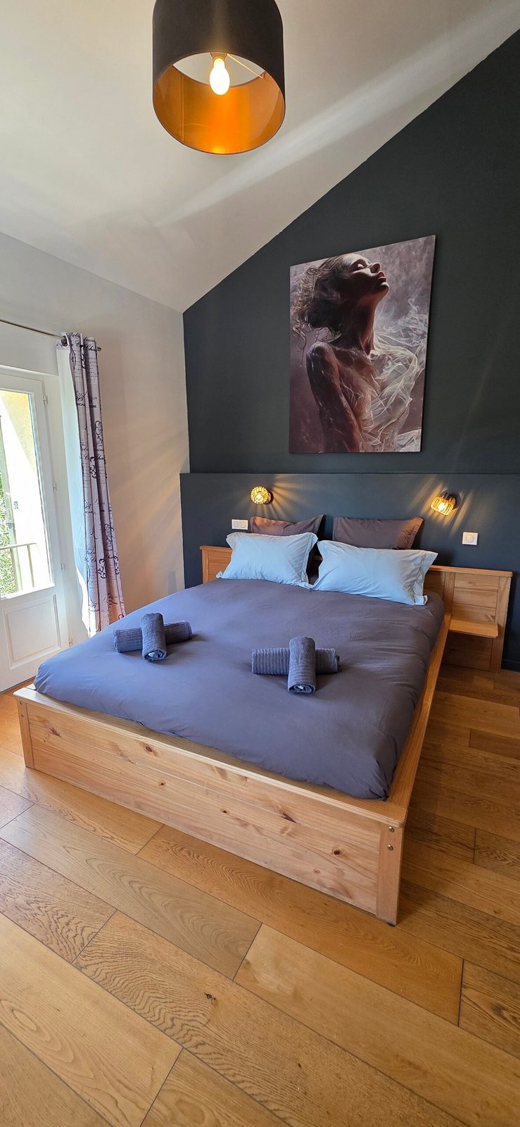 Chambre en pierre claire avec literie en lin et volets entrouverts